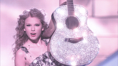 gif of taylor swift smiling while holding sparkly guitar, fearless era